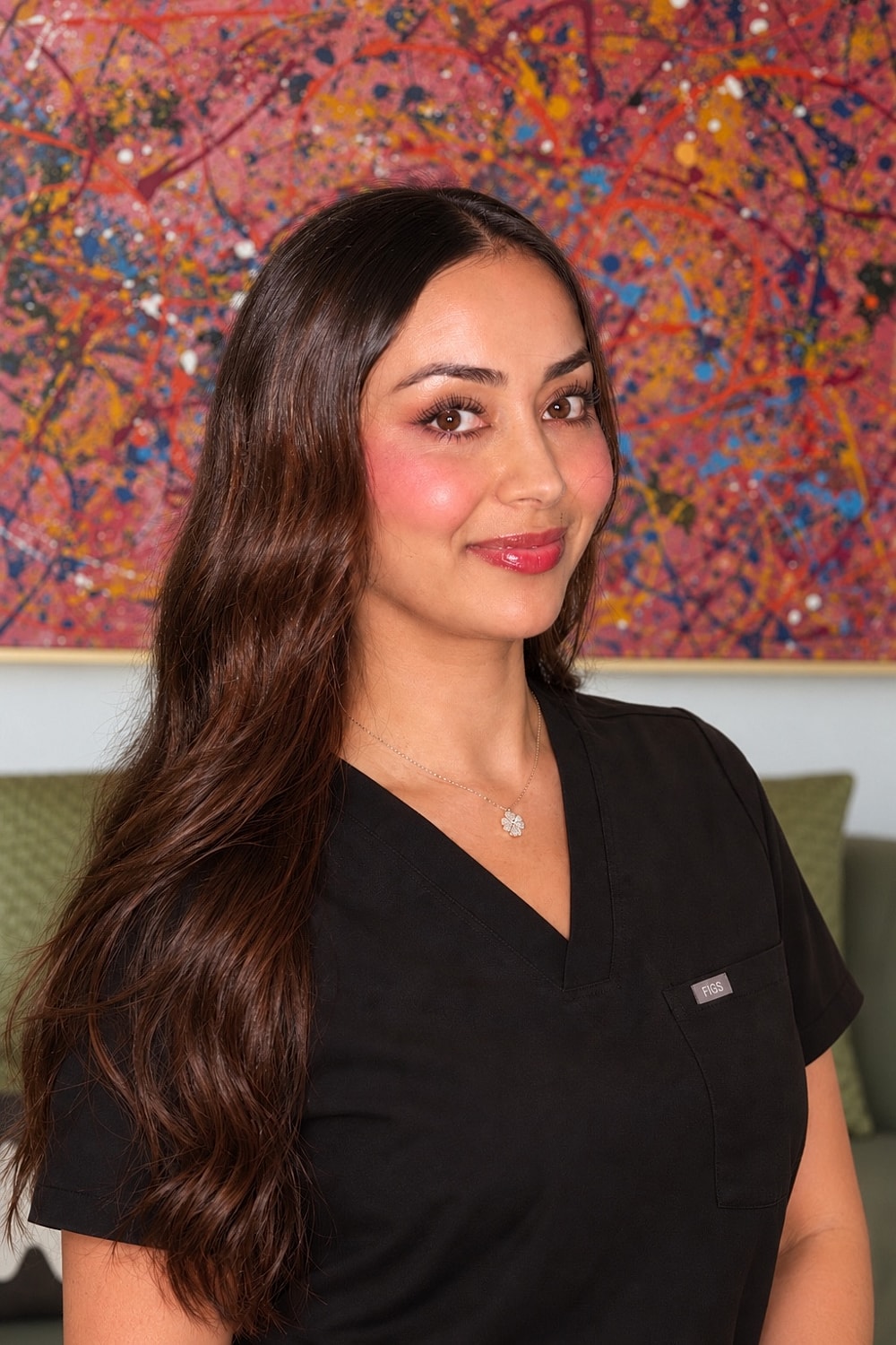 Woman in black scrubs with long hair.