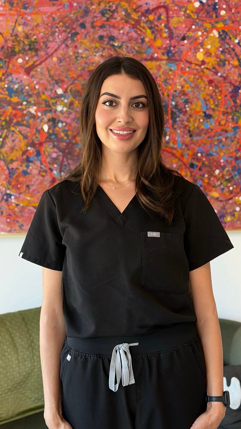 Smiling woman in black scrubs, colorful background.