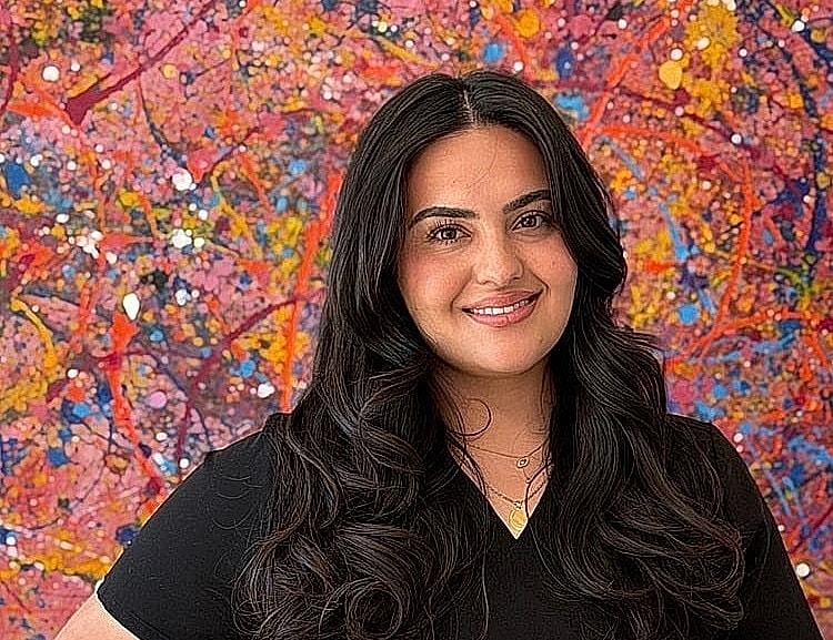 Woman smiling against colorful abstract background.